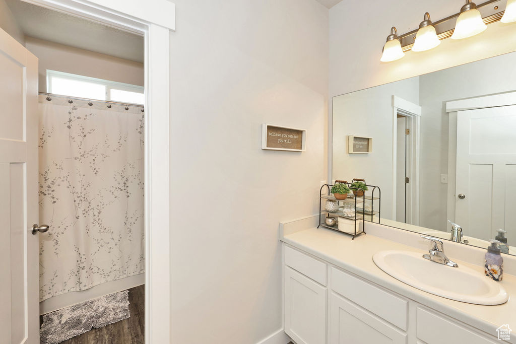 Bathroom featuring shower / bath combination with curtain and vanity