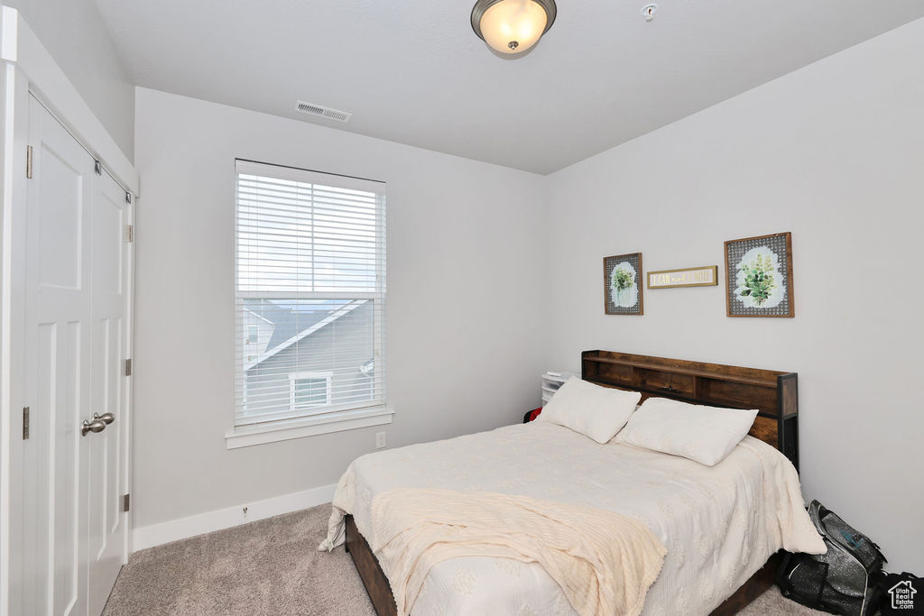 Carpeted bedroom with baseboards and visible vents