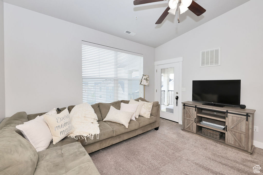 Living area featuring visible vents, a ceiling fan, carpet floors, and lofted ceiling