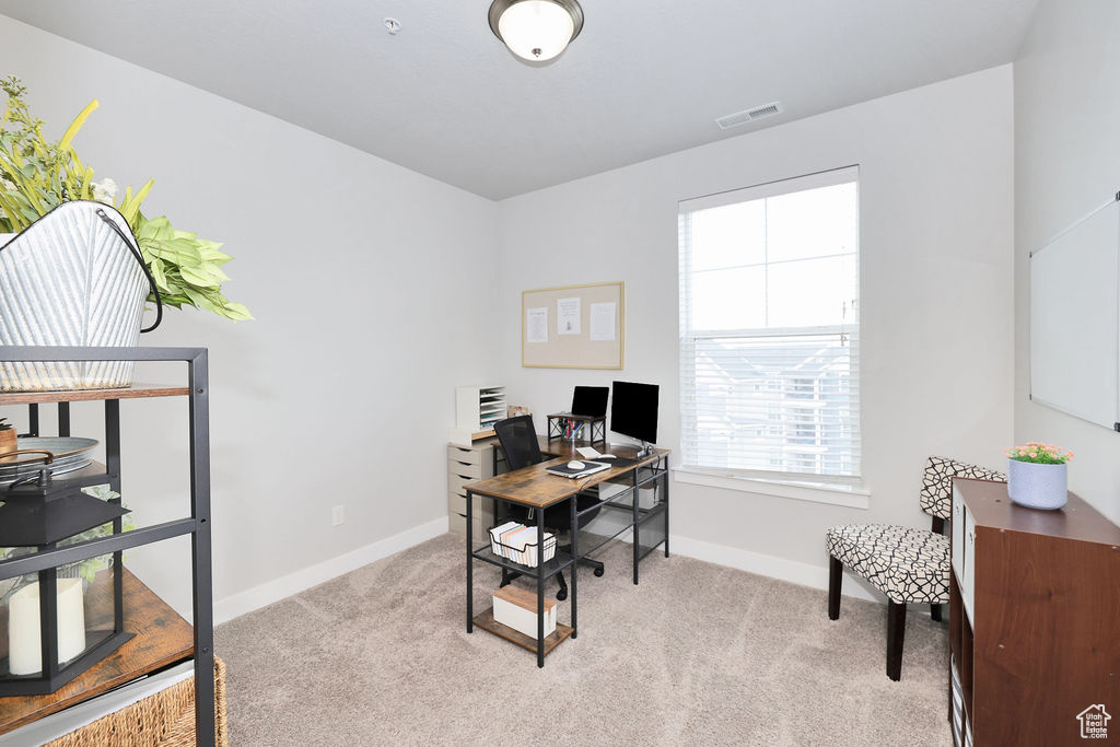 Office featuring visible vents, baseboards, and light carpet
