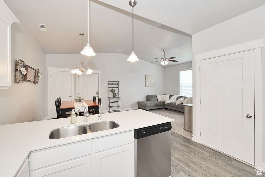 Kitchen featuring hanging light fixtures, dishwasher, a sink, light countertops, and light wood-style flooring