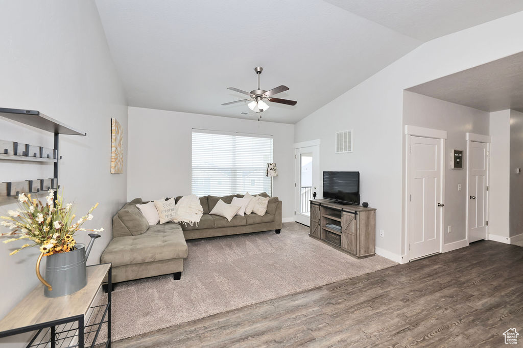 Living room with visible vents, wood finished floors, lofted ceiling, baseboards, and a ceiling fan
