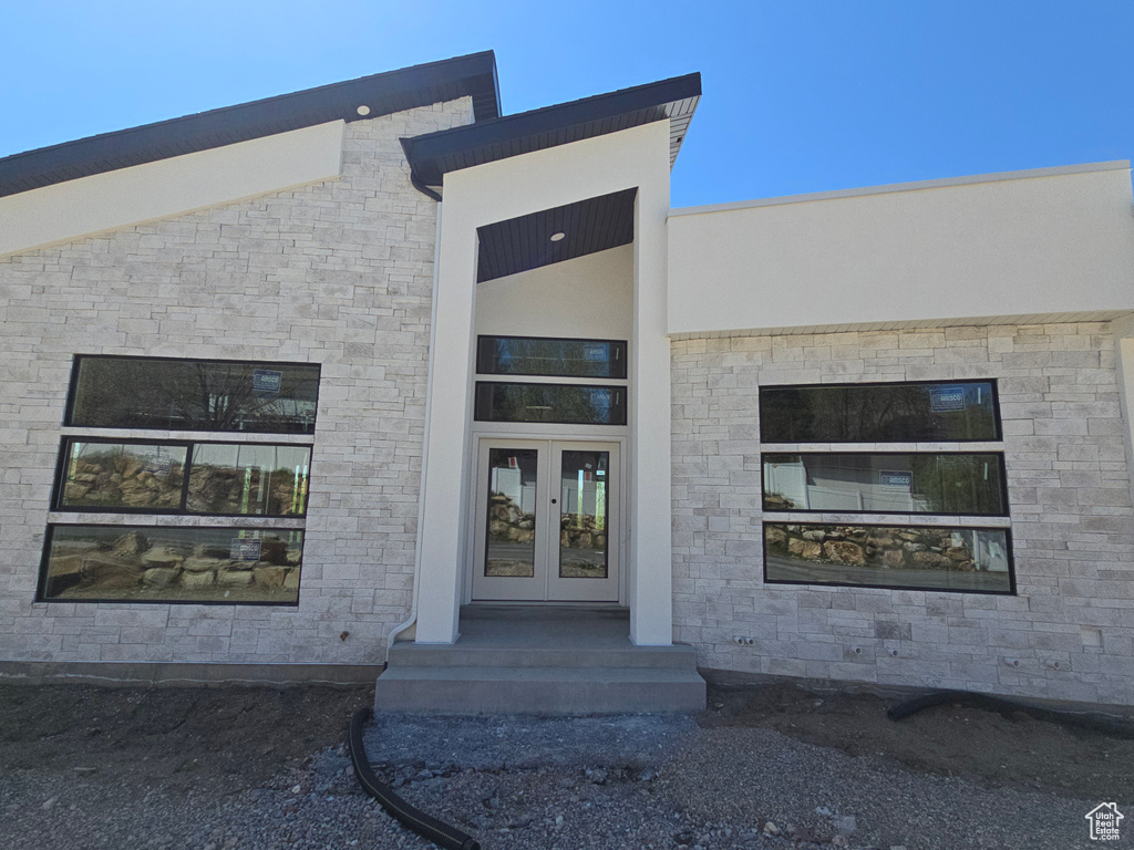 View of exterior entry featuring french doors and stone siding