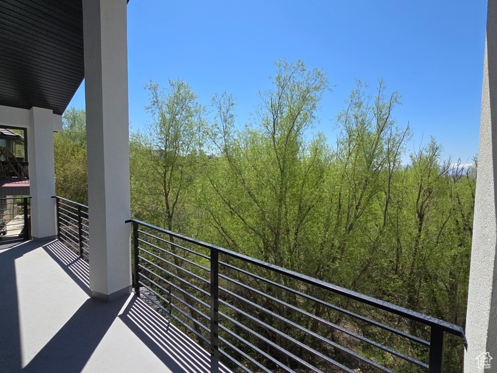 Balcony featuring a wooded view