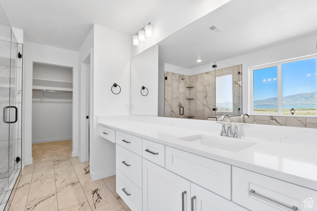 Full bath featuring a stall shower, marble finish floor, visible vents, vanity, and a walk in closet