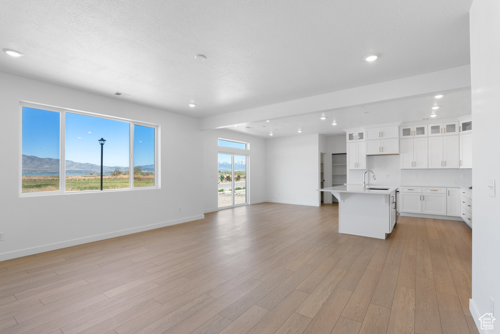 Interior space featuring baseboards, light wood-style flooring, and a sink