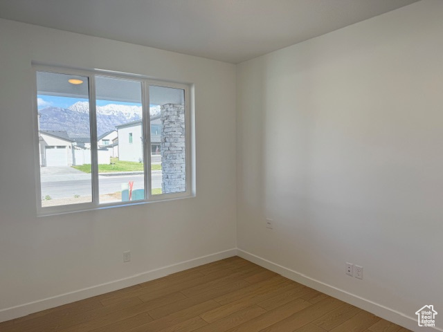 Unfurnished room with baseboards and light wood-type flooring