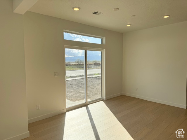 Empty room with visible vents, recessed lighting, light wood finished floors, and baseboards