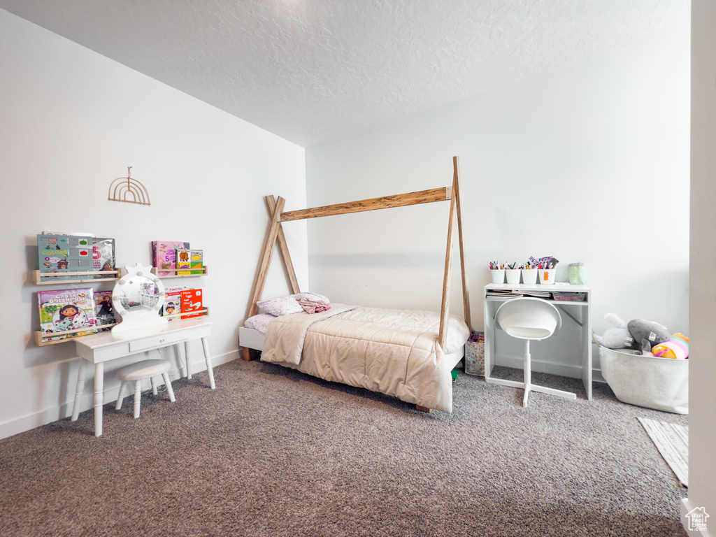 Bedroom with carpet floors, a textured ceiling, and baseboards