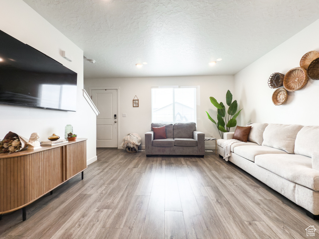 Living room with a textured ceiling and wood finished floors