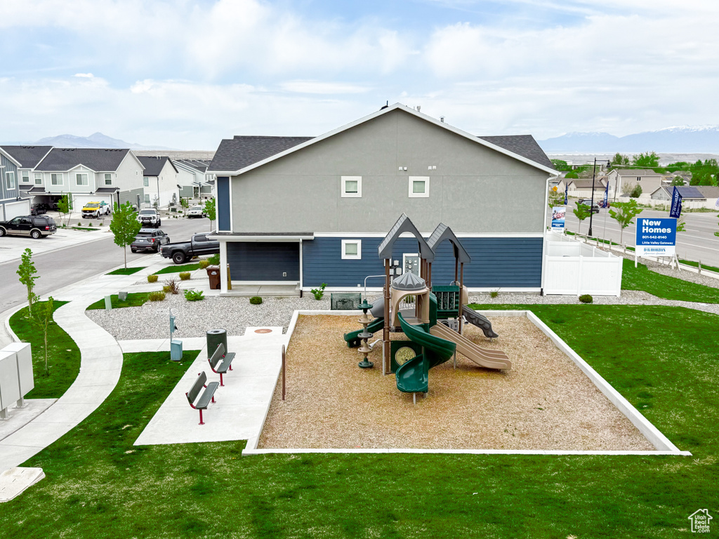 Exterior space with a yard, fence, a residential view, and playground community