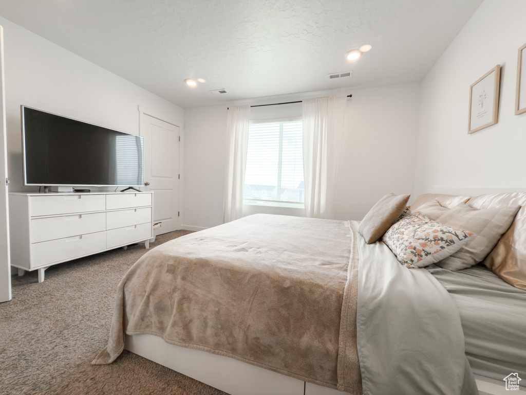 Carpeted bedroom with visible vents and recessed lighting
