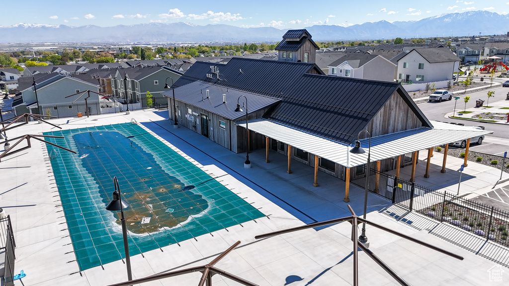 Pool featuring a patio, fence, a residential view, and a mountain view