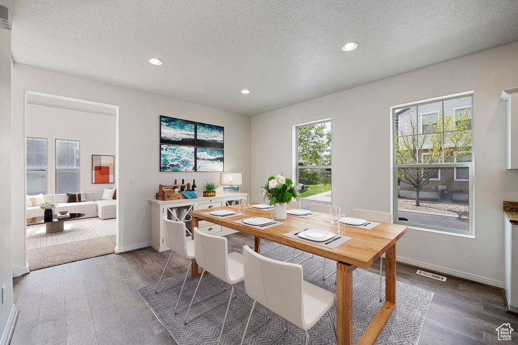 Dining room with baseboards, visible vents, wood finished floors, and recessed lighting