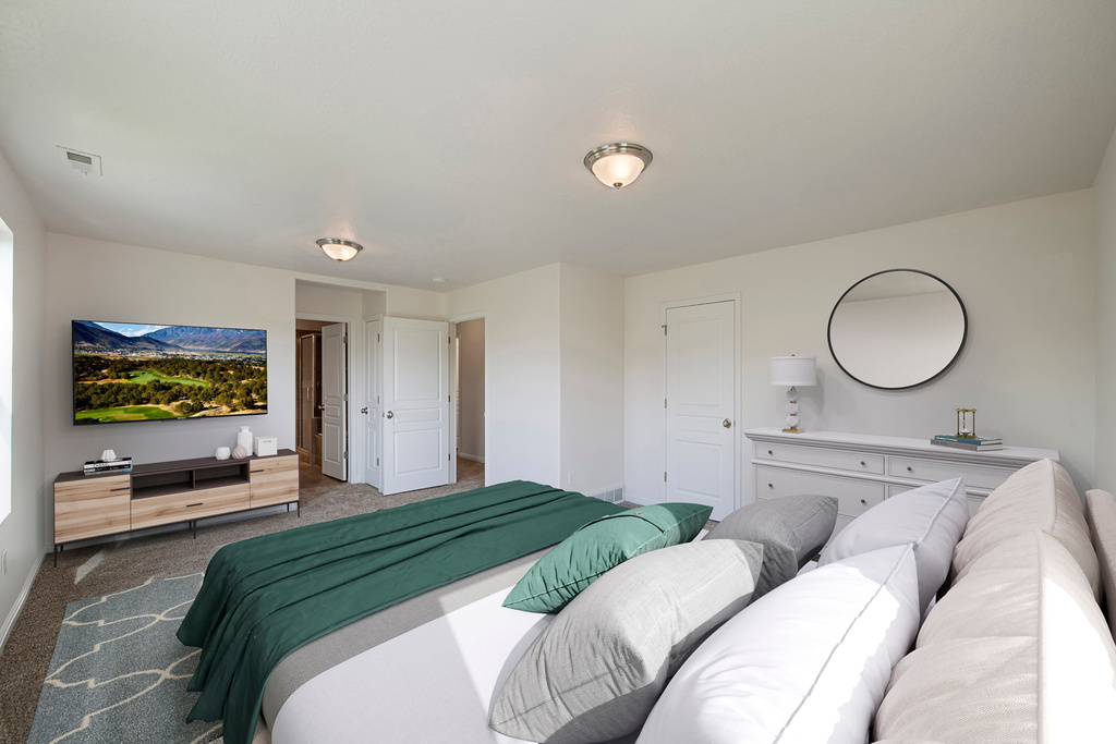 Carpeted bedroom featuring baseboards and visible vents