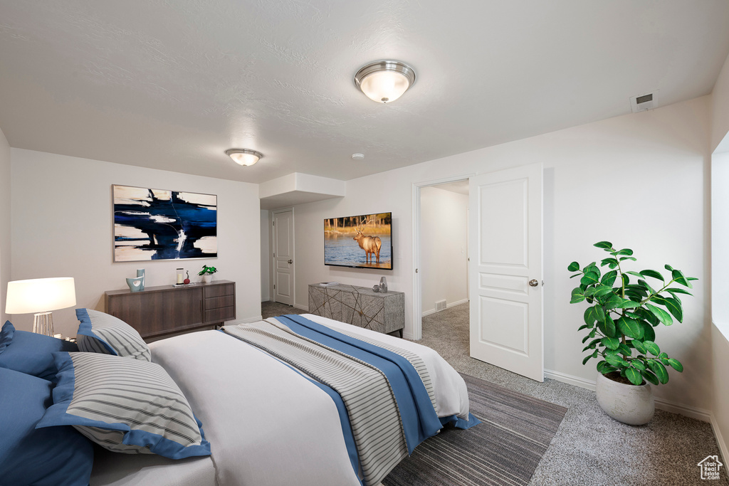 Carpeted bedroom featuring visible vents and baseboards