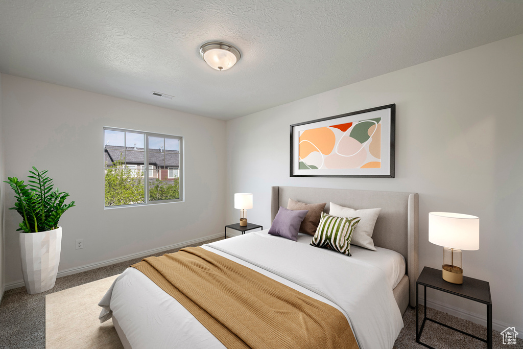 Carpeted bedroom with baseboards, visible vents, and a textured ceiling