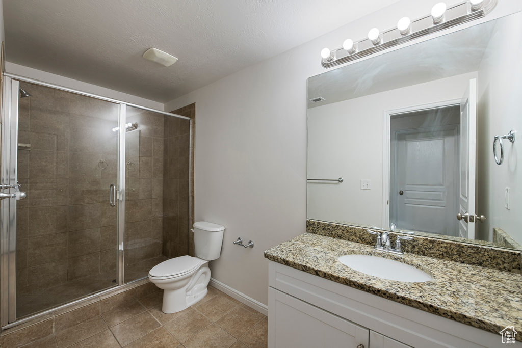 Full bathroom with vanity, toilet, a shower stall, and baseboards