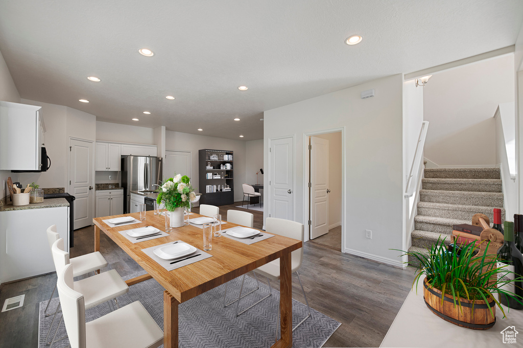Dining room with recessed lighting, stairs, and dark wood-type flooring