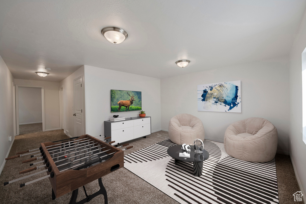 Living area featuring carpet flooring and baseboards