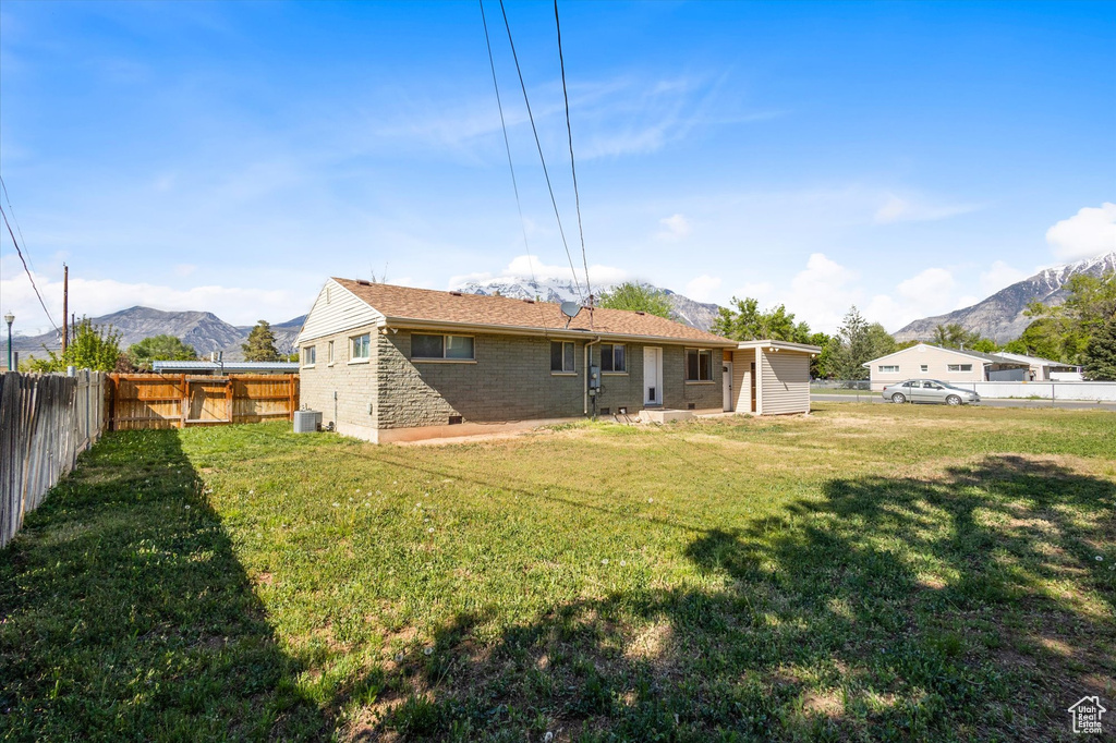 Rear view of property featuring a mountain view, central AC, and brick siding
