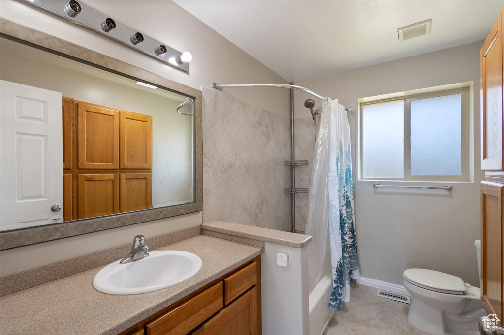 Full bath featuring toilet, vanity, shower / tub combo, and tile patterned flooring