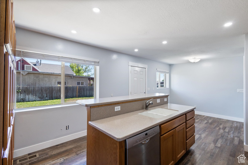 Kitchen with a sink, stainless steel dishwasher, dark wood-type flooring, healthy amount of natural light, and recessed lighting