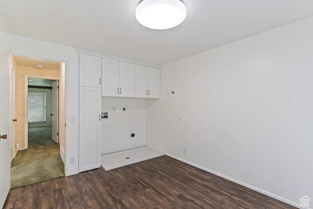 Laundry room featuring washer hookup, dark wood-style flooring, electric dryer hookup, cabinet space, and baseboards