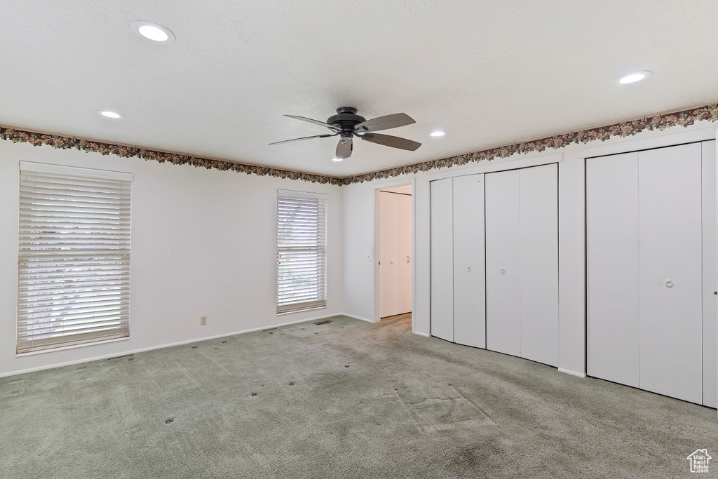 Unfurnished bedroom featuring a ceiling fan, baseboards, multiple closets, carpet flooring, and recessed lighting