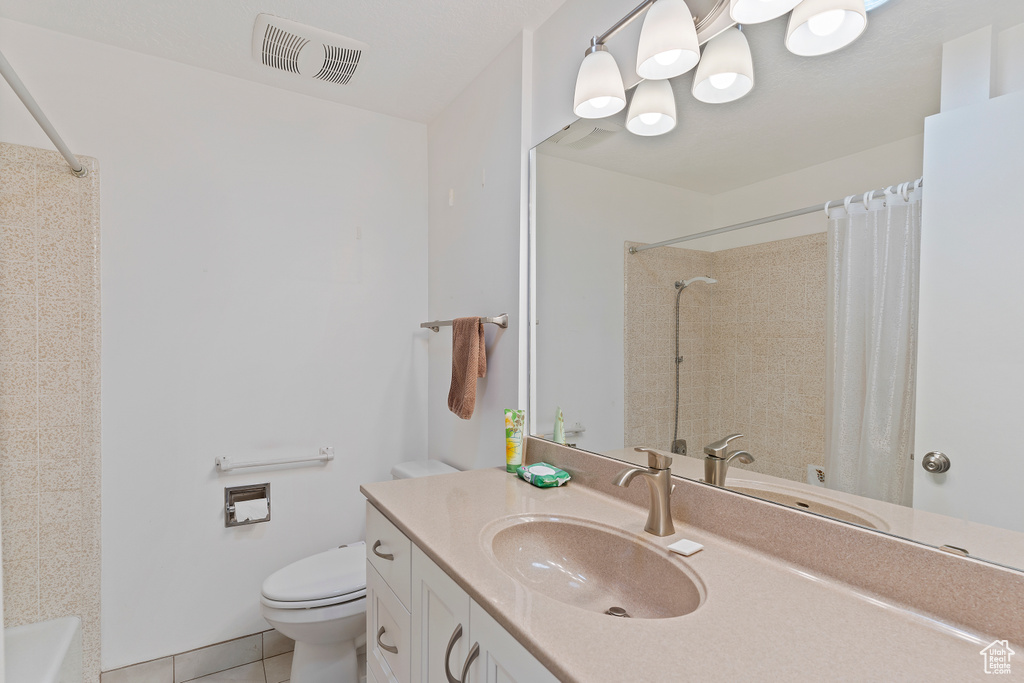 Full bath with tile patterned floors, vanity, toilet, and visible vents