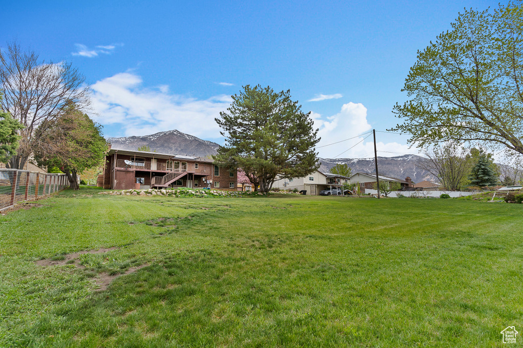 View of yard featuring stairs, a mountain view, and fence