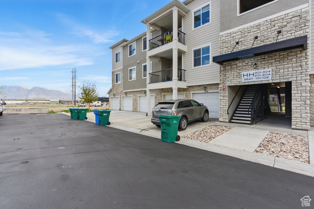 View of building exterior with driveway, a mountain view, and an attached garage