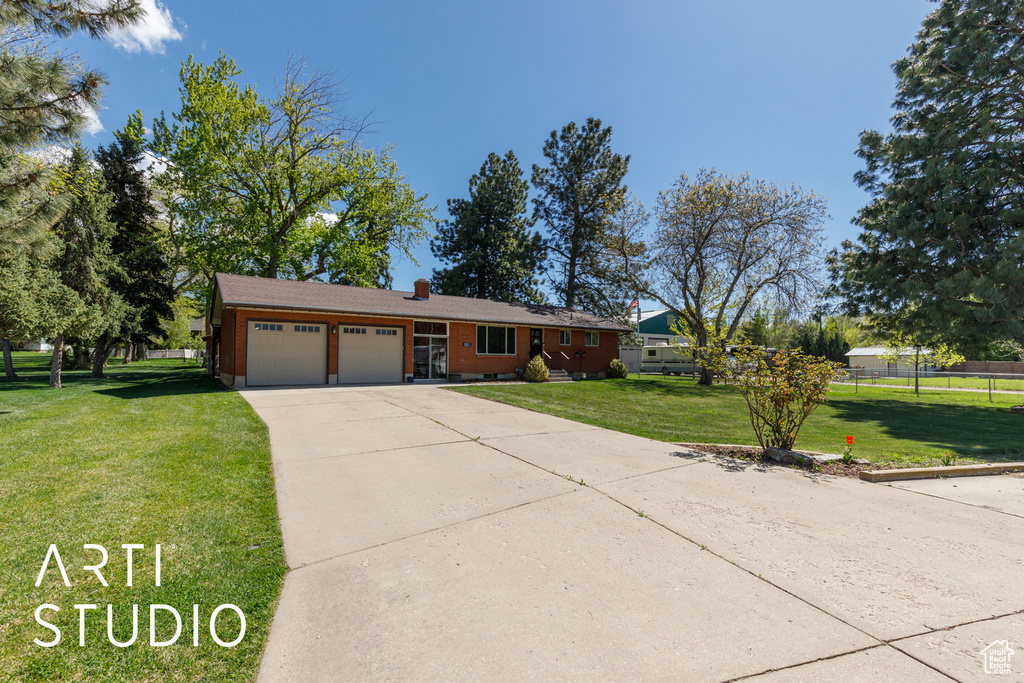 Ranch-style home with fence, an attached garage, a front lawn, a chimney, and driveway