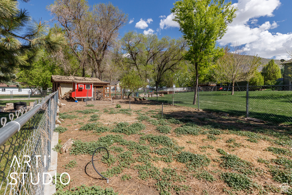 View of yard with fence and an outdoor structure
