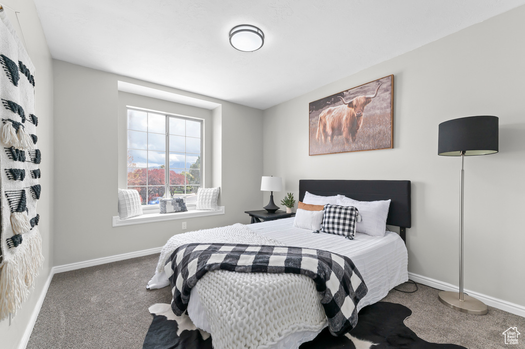 Bedroom featuring carpet floors and baseboards