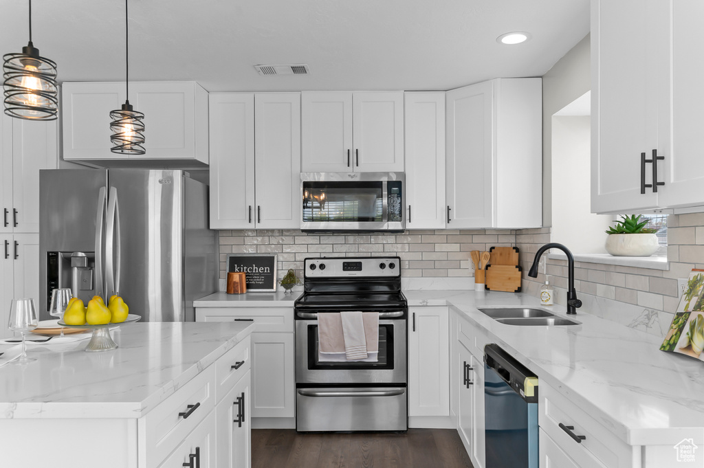 Kitchen featuring visible vents, a sink, appliances with stainless steel finishes, and light stone countertops