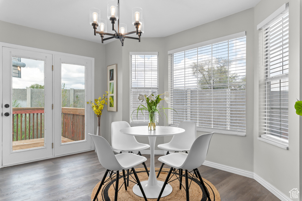 Dining room with baseboards, a chandelier, and dark wood-style floors
