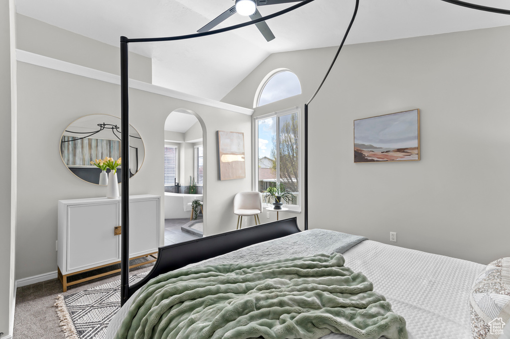 Bedroom featuring ceiling fan, arched walkways, carpet, baseboards, and lofted ceiling
