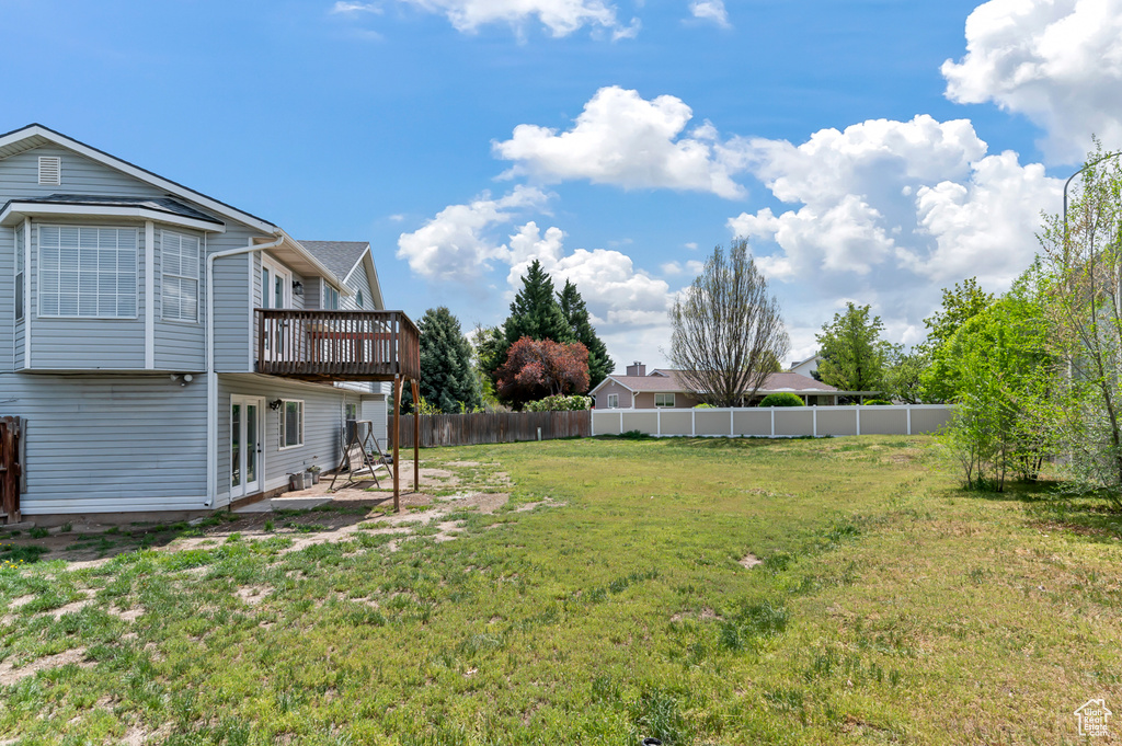 View of yard featuring a deck, fence, and a patio