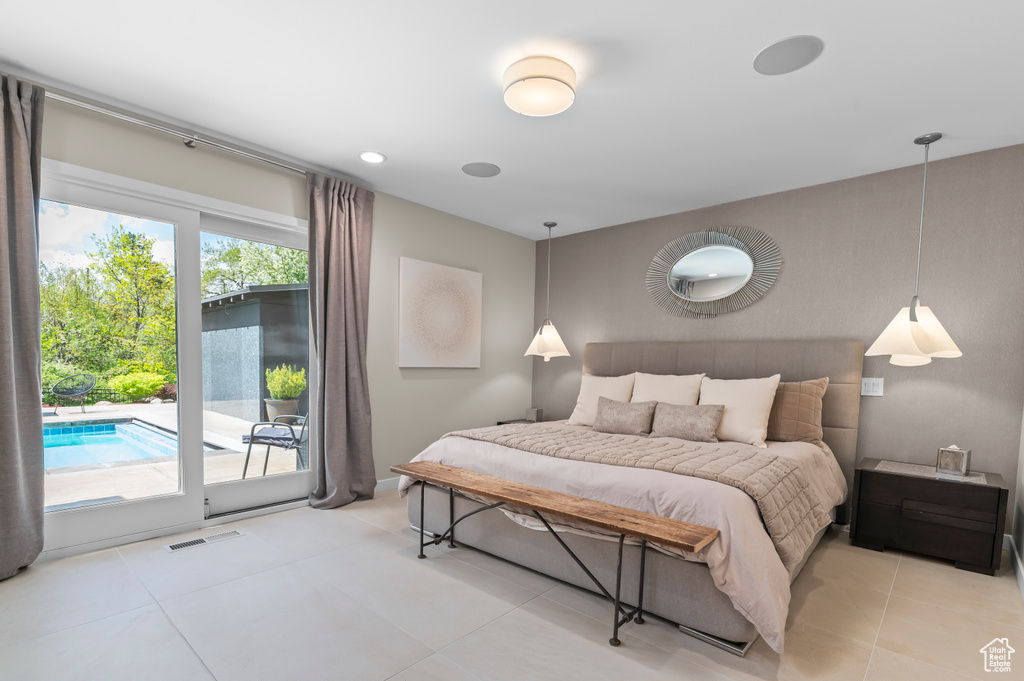 Bedroom with visible vents, light tile patterned floors, and access to exterior