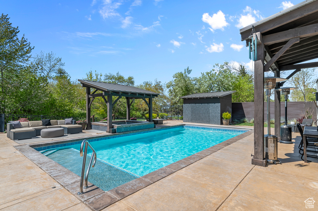 View of swimming pool with a storage shed, a patio area, a gazebo, a fenced in pool, and an outdoor structure