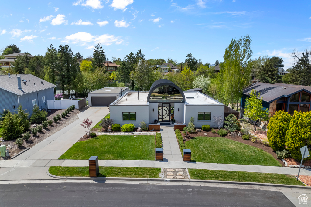 View of front of house featuring a garage, a residential view, and a front yard