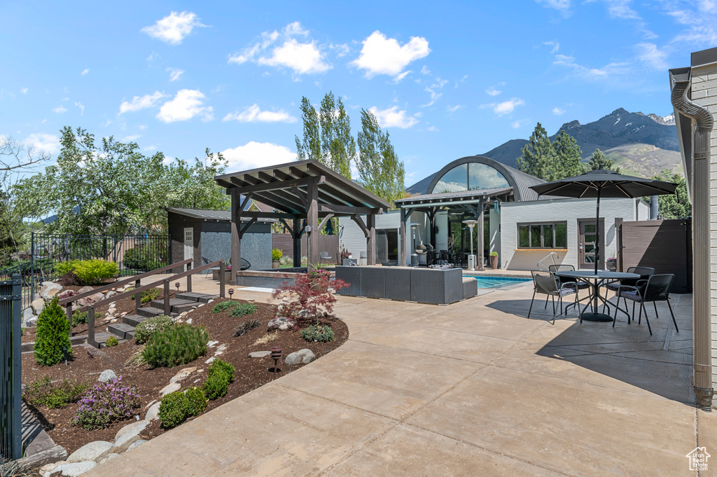 View of patio with fence, a fenced in pool, a gazebo, an outbuilding, and outdoor dining space