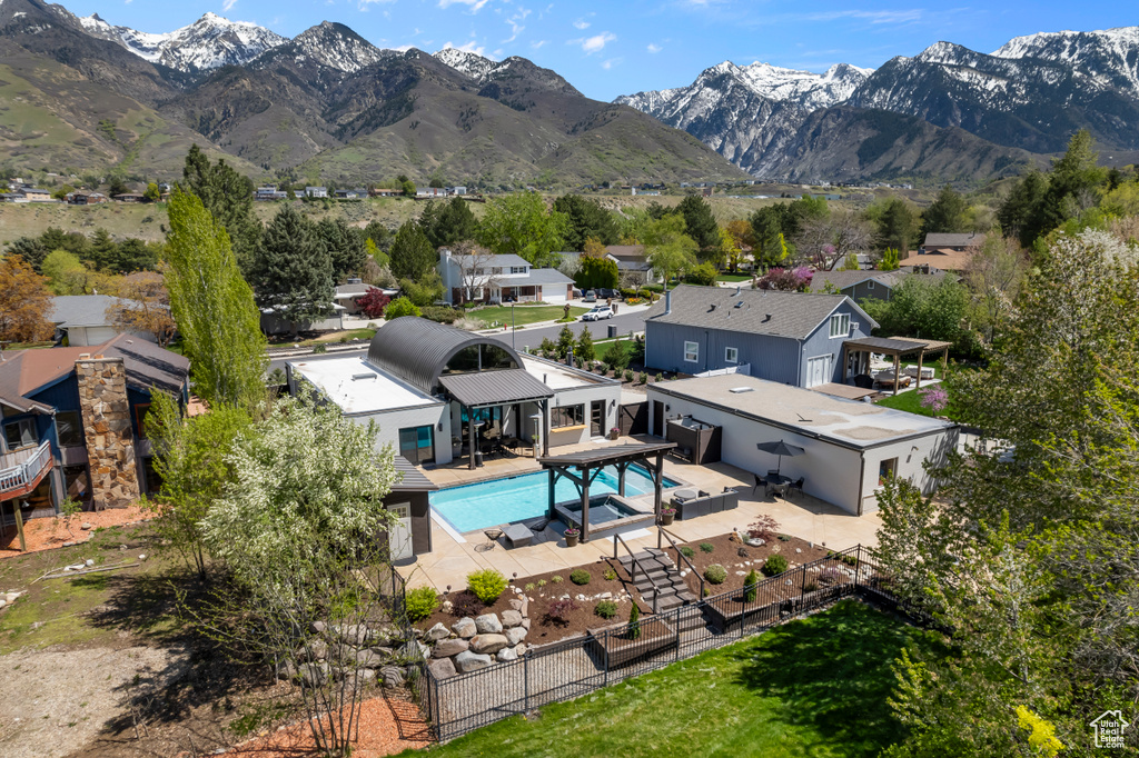 Exterior space featuring a mountain view, a residential view, a fenced backyard, and a patio area