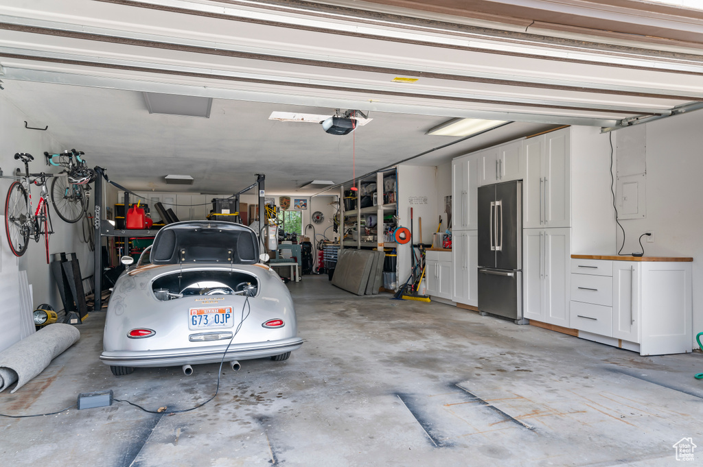 Garage featuring high quality fridge and a garage door opener