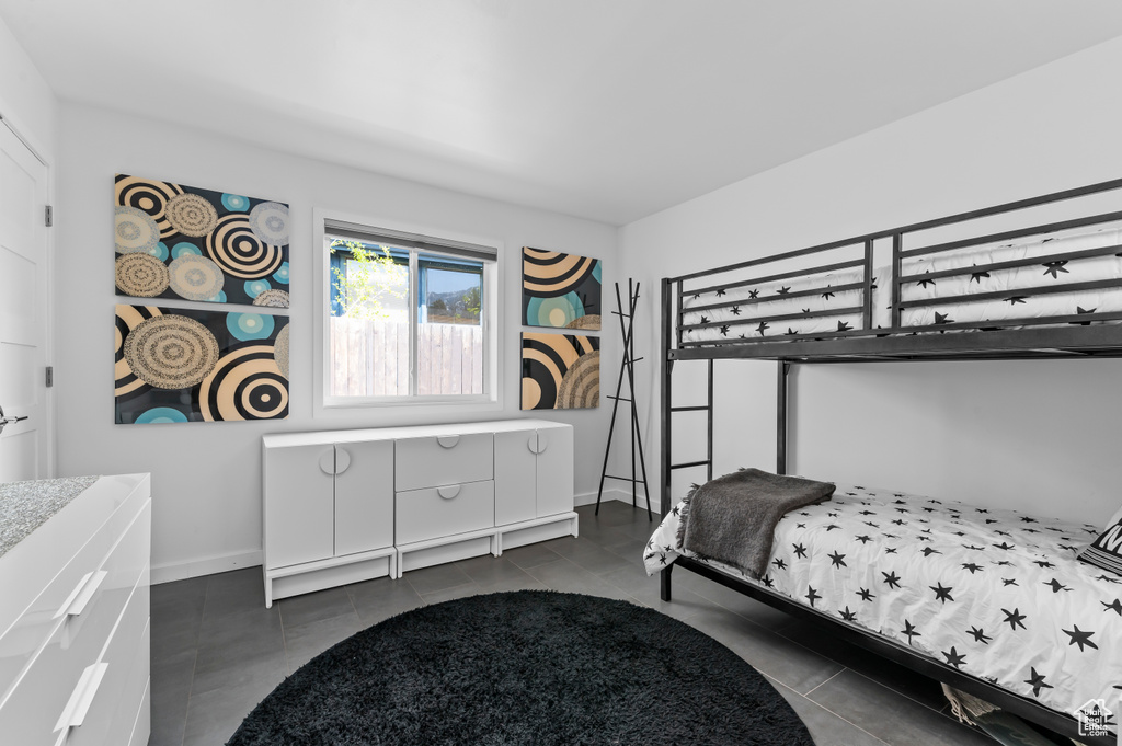 Bedroom featuring baseboards and dark tile patterned flooring