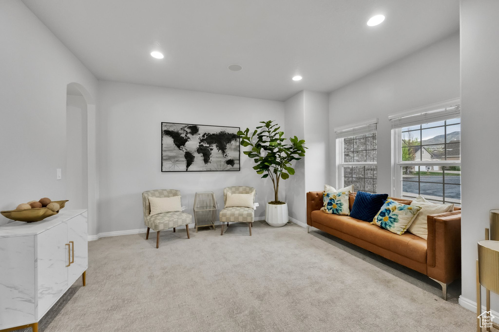 Sitting room with arched walkways, baseboards, recessed lighting, and carpet