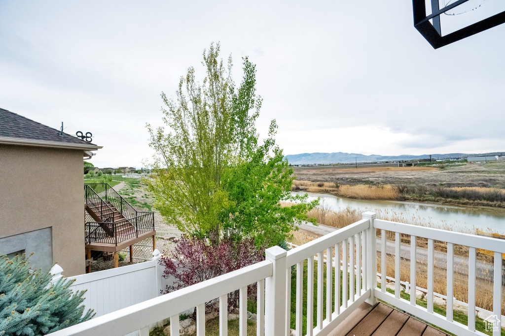 Balcony featuring stairs and a water and mountain view