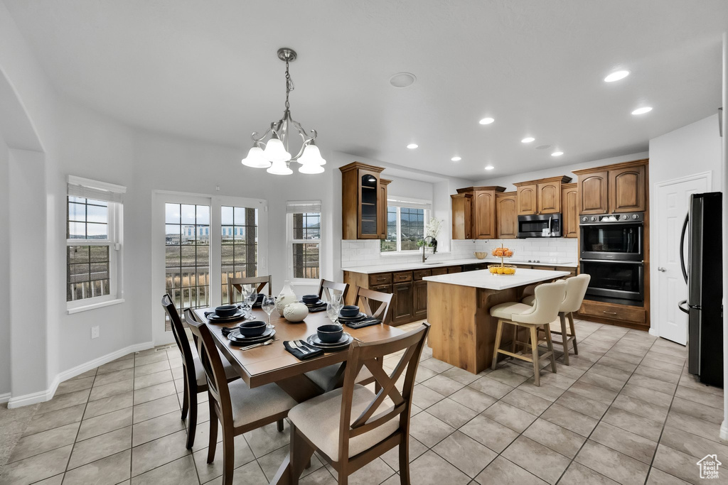 Dining space featuring recessed lighting, light tile patterned flooring, a chandelier, and a wealth of natural light