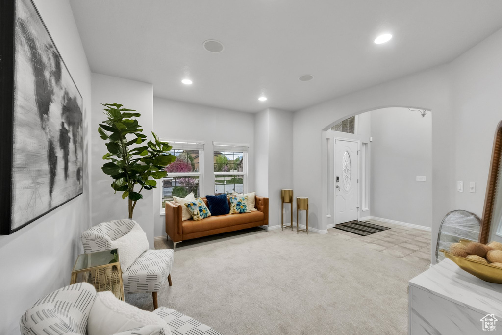 Living room featuring arched walkways, baseboards, and recessed lighting